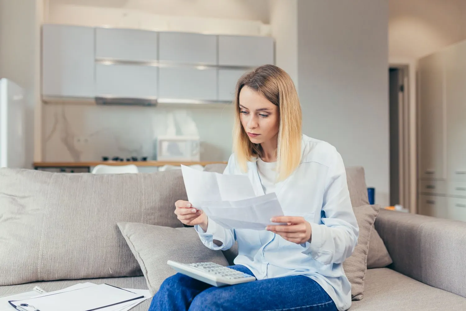 Woman reviewing bills at home for water bill assistance programs